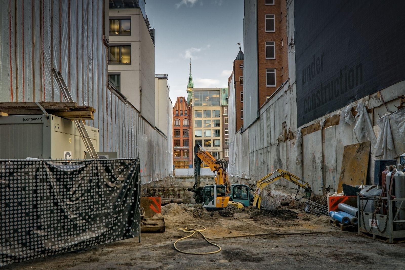 Urban site excavation between buildings with mini excavators at work
